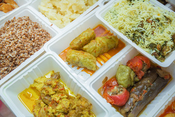 Delivery sets of healthy and delicious food in boxes . A variety of fast food in plastic boxes .