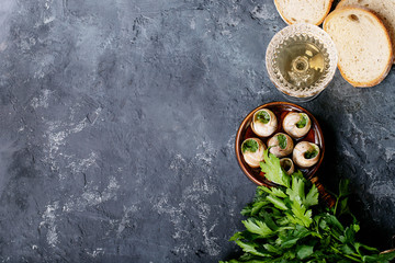 Baked snails with garlic butter and fresh herbs in a frying pan, selective focus