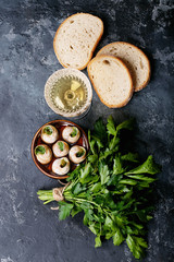 Baked snails with garlic butter and fresh herbs in a frying pan, selective focus