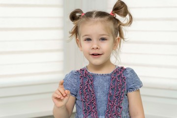 little girl 4 years old in a blue dress, playful face