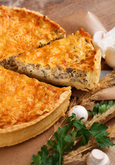 Homemade tart with puff pastry with mushrooms, cheese, onion, parsley and dill on rustic wooden table. Top view.