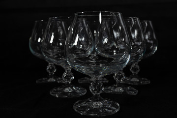 six clear crystal glasses on a dark background