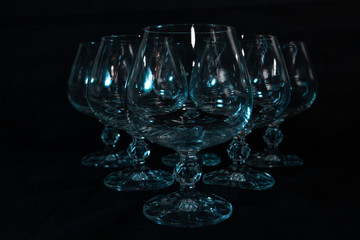 six clear crystal glasses on a dark background
