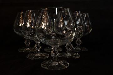 six clear crystal glasses on a dark background