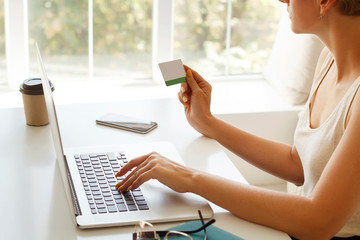 Picture of close up woman’s hands with credit card making shopping at laptop