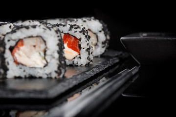 Sushi with black sesame, salmon and cheese. Frame for Japanese menu or for advertising.