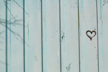 Drawing of a heart on a wooden fence.