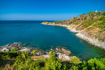 Fototapeta na wymiar View of the rocky cliffs and clear sea under the bright sun. Promthep cape. Viewpoint in Phuket Thailand