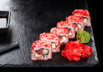 Sushi roll with seafood and soy sauce, wasabi and ginger.