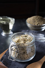 Organic kernels hemp in glass jar on black. Vertical format.