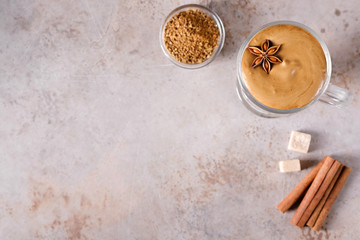 Whipped dalgona coffee with spices on a beige background with copy space. Korean coffee drink. Flat lay composition