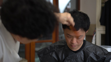 Asian family mother do barber haircut for son at home during quarantine time