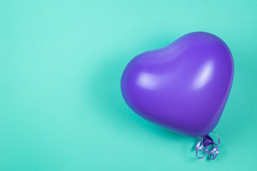Purple ballon on green background. Copy space.