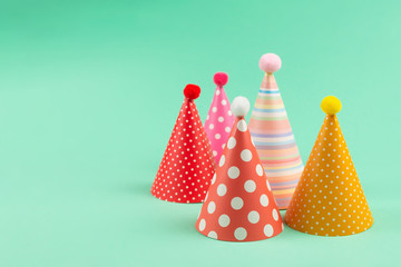 Colorful birthday caps on mint background.