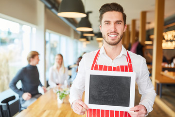 Service staff with chalkboard in the restaurant