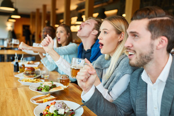 Young people are looking football game in the restaurant