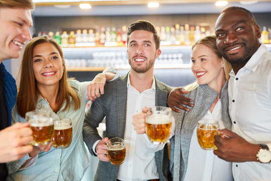 Group of friends drinking beer in pub or bar