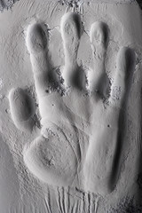 handprint in sand or stone with shadows