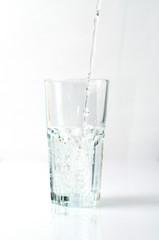 Splashing liquid, water is pouring into a glass