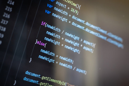 Javascript web developer programming code with screen glare