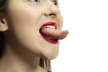 Smiling girl opening her mouth and showing the long big giant tongue isolated on white background....