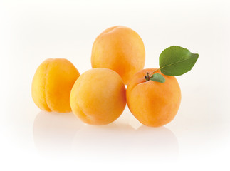 Fresh apricots with leaves isolated on white background