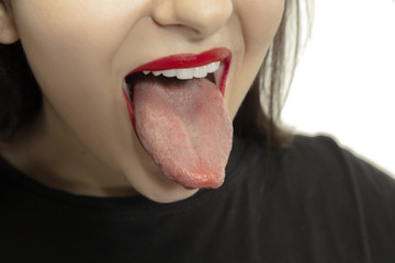 Smiling girl opening her mouth and showing the long big giant tongue isolated on white background....