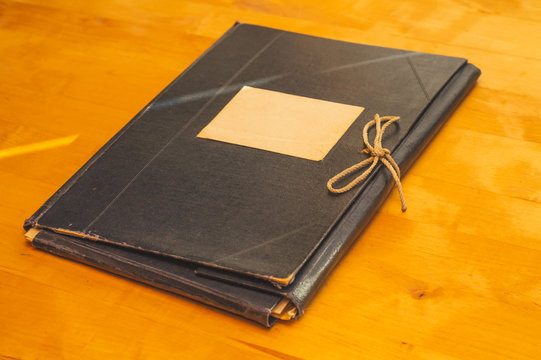 Vintage folder for paper with blank label. old folder for documents lies on a wooden table