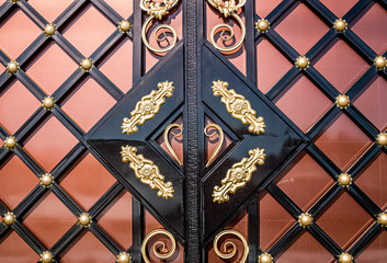 Forged and painted metal gate elements close-up as a background.