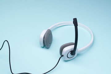 Headphones with microphone isolated on clear blue background.
