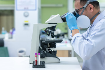 Scientists are studying research on the germs that cause COVID-19, the main cause of illness and are spreading in the world. (focus at tube)