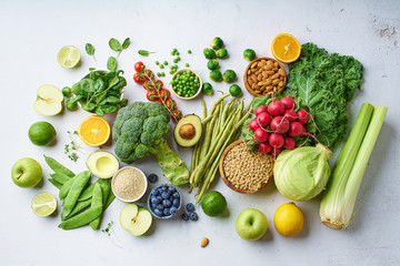 Creative flat lay with healthy vegetarian meal ingredients. Raw food concept. A variety of organic fruits, nuts, berries and vegetables with avocado. Vegan menu.