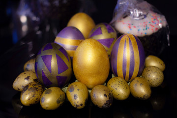 Purple golden Easter eggs on a black background