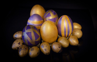Purple golden Easter eggs on a black background