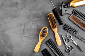 Hairdresser set in beauty salon. Combs, sciccors, spray on grey desk top-down copy space