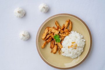 Fried meat chicken with black pepper and Garlic sauce oserved with Thai jasmine rice on the plate. isolated on white background.In Thai it call 