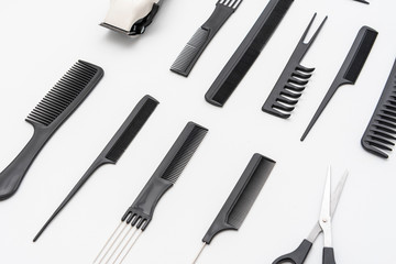 Peines , tijeras y rasuradora acomodados sobre un fondo blanco
