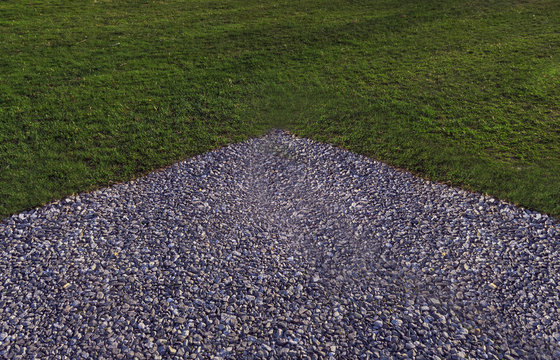 Corner Of A Gravel Parking Lot At The Edge Of A Lawn In A Public Park