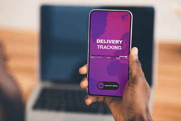 Close-up of african man holding mobile phone with app on screen