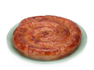 Grilled homemade sausage ring in a plate on white background