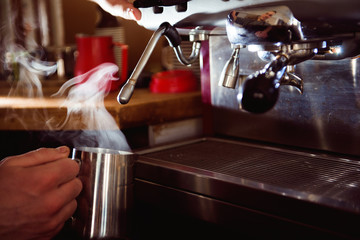Barista preparing coffee in a coffee shop. Professional coffee making, service and catering concept