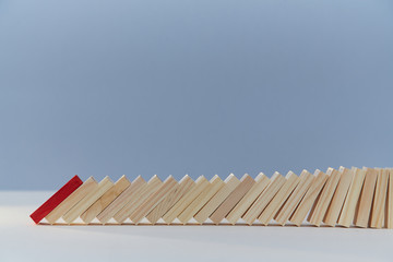 Falling domino blocks, red plank, copy space. Beginning of end. Financial difficulties. Total collapse, economic crisis