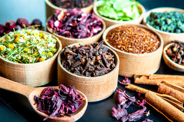 Various dried tea leaves in wooden bowl. Dried herbs tea leaves close up. Different dry herbs and...