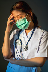 Doctor Asian woman  is depressed about epidemic and has stress in Coronavirus outbreak. Emotional stress of overworked doctor.