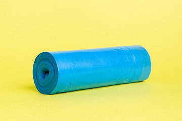 Roll of blue garbage bags on a yellow background