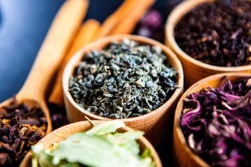 Various dried tea leaves in wooden bowl. Dried herbs tea leaves close up. Different dry herbs and...