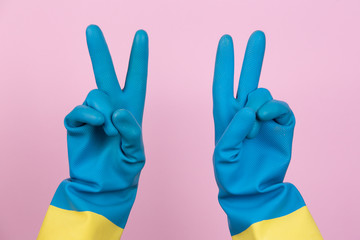 A cleaning gloved hand making the victory gesture