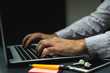 Remote work at home, close-up image of a young professional male manager with a laptop. Corona virus. Entrepreneur working at home using a laptop computer.