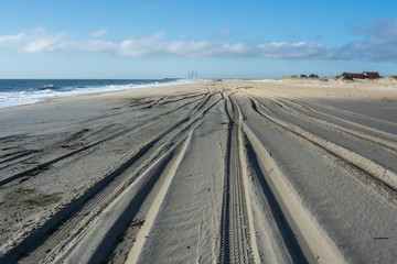 Closed, deserted  COVID beach looking toward Life Saving Station and Indian River Inlet Bridge in distance at Delaware Seashore State Park