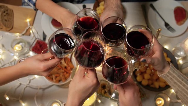 holidays, celebration and people concept - friends having christmas dinner party and drinking non-alcoholic red wine at home